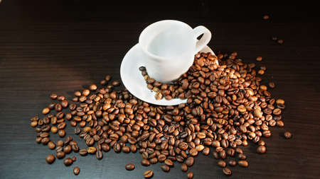 White Cup With Coffee Beans on Black Background.