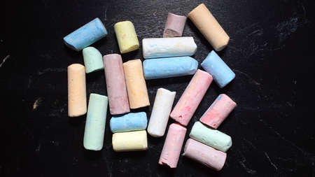 Colored chalks aligned on blackboardの写真素材