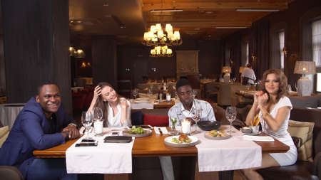 Group Of Young Friends Enjoying Meal In Restaurantの写真素材