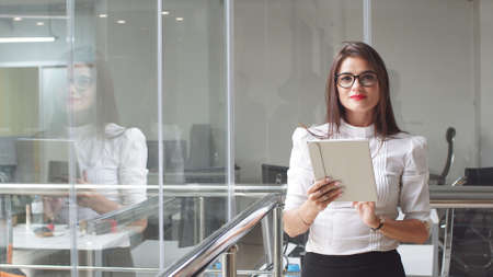 Portrait of sexy business woman in glasses with a tabletの写真素材