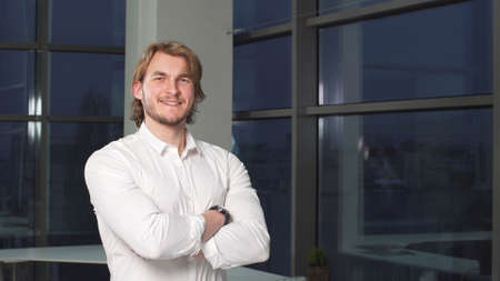 Portrait of a modern male freelancer in office interior of evening.