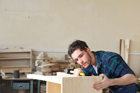 Handsome Joiner Work in Carpentry. He is Successful Entrepreneur at His Workplaceの写真素材
