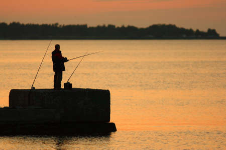 Fisherman silhouette against the backdrop of the Bayの写真素材
