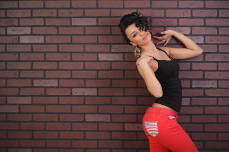 sexy brunette on a background of brick wall