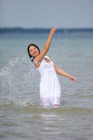 girl standing in water in white dress