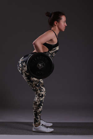 Beautiful fitness girl liftings weightsの写真素材