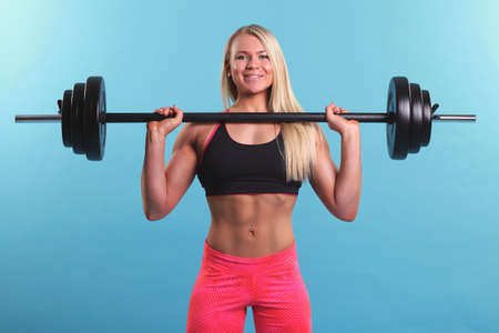 Beautiful fitness girl liftings weights. studio photoの写真素材