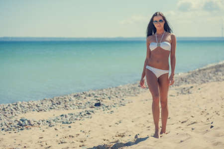 young woman on the sea in a white bikiniの写真素材
