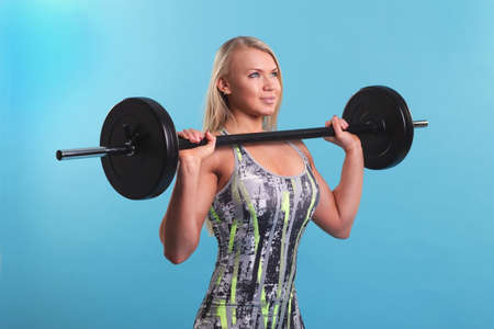 Beautiful fitness girl liftings weights. studio photo