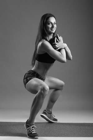 Beautiful fitness girl liftings weights. studio photoの写真素材