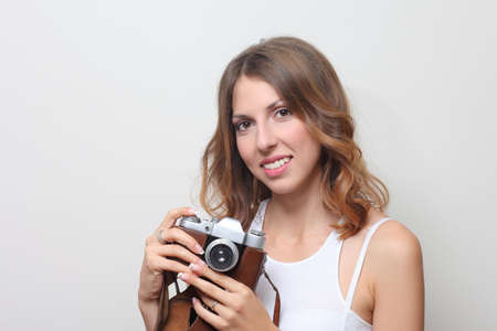 young girl with the camera, studio photo on a background of a wallの写真素材