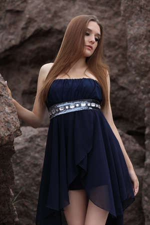 Portrait of a beautiful young women with makeup in nature on a background of big stonesの写真素材