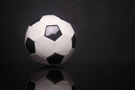 classic black white soccer ball on black backgroundの写真素材