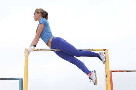 Sexy and young girl practicing on the horizontal bar