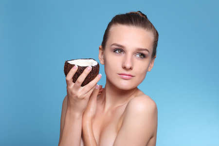 Cute girl holding half of coconut in handsの写真素材