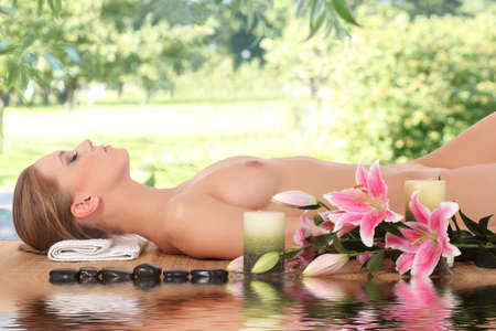 woman relaxing in spa, with reflection on the waterの写真素材