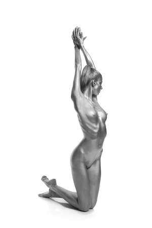 Beautiful naked slender girl posing on a gray backgroundの写真素材