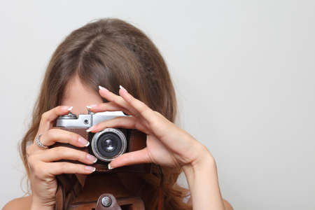 woman photographer holding a film camera in handsの写真素材