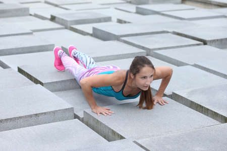 young strong fitness athletic girl doing push-upsの写真素材
