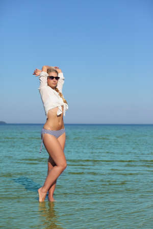 young sexy woman in bikini and white shirtの写真素材