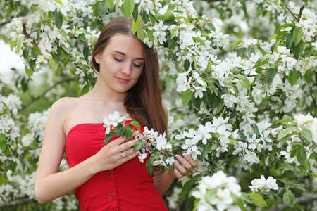 young happy woman walking in garden with apple treesの写真素材