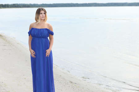 Young woman in long dress on sand beachの写真素材