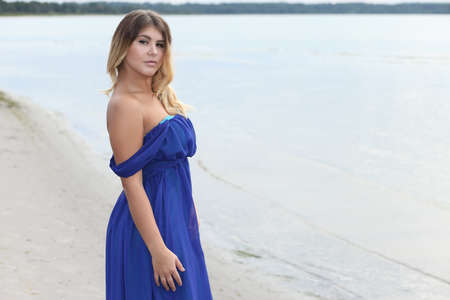 Young woman in long dress on sand beachの写真素材