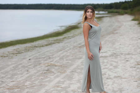 Young sexy girl in long dress on beachの写真素材