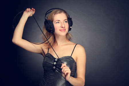 young cheerful girl listening to music on headphonesの写真素材