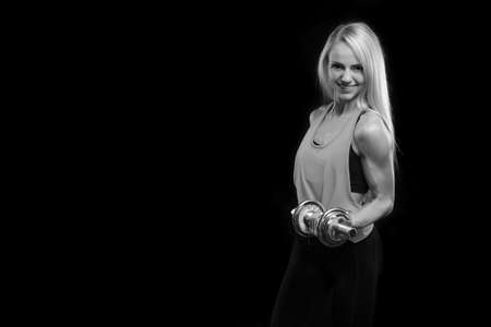 young sporty slim muscular girl with dumbbells