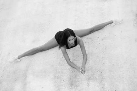Young attractive female fitness woman performing a twine