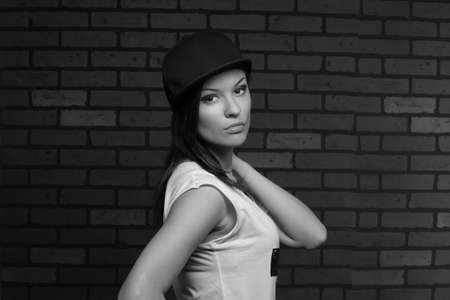 young serious girl posing in a black capの写真素材