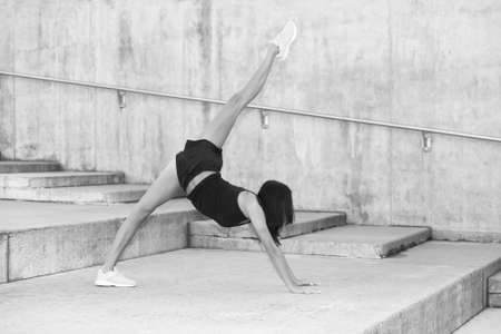 Young attractive female fitness woman performing a twine