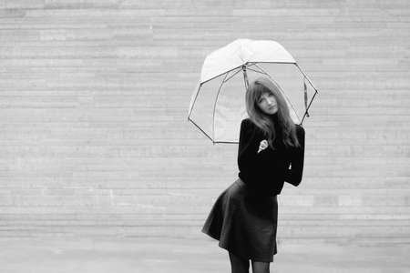 Black and white portrait of a young girl with an umbrellaの写真素材