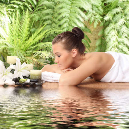 woman lying down relaxing on a massage bed at a spaの写真素材