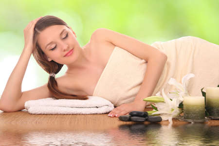 woman lying down relaxing on a massage bed at a spaの写真素材