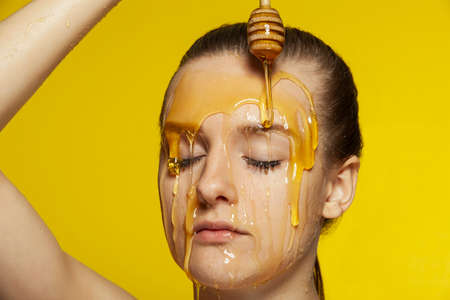 Woman with honey on her face. Honey treatmentの写真素材