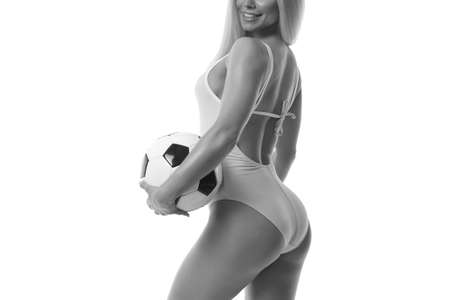 sexy young woman wearing bikini and holding soccer ball.の写真素材