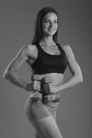 fitness woman in sportswear doing exercises with dumbells.の写真素材