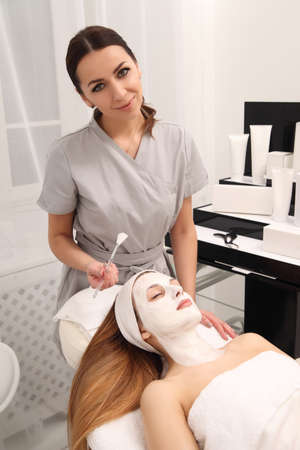 Woman getting beauty skin mask treatment on face with brushの写真素材
