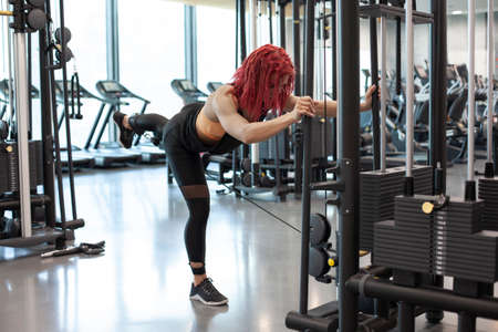 young athletic girl trains in a fitness gym