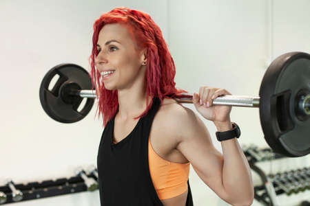 young athletic girl trains in a fitness gym