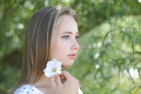 summer portrait of a young cute girl on a green backgroundの写真素材