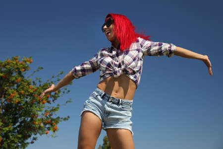 young happy girl in a shirt and denim shortsの写真素材