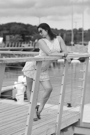 young woman in a slender dress near the yachtsの写真素材