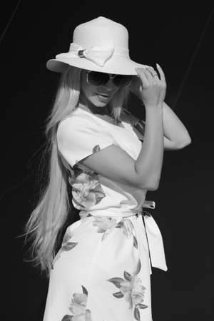 stylish young woman in dress and white hatの写真素材