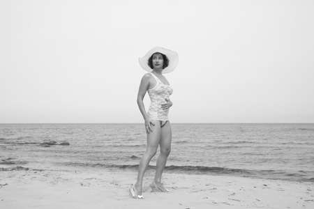 young sexy woman on wild beach in white