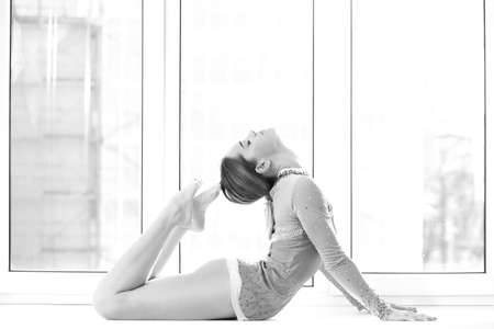 athletic woman in swimsuit posing on the windowの写真素材