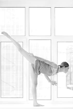 athletic woman in swimsuit posing on the windowの写真素材