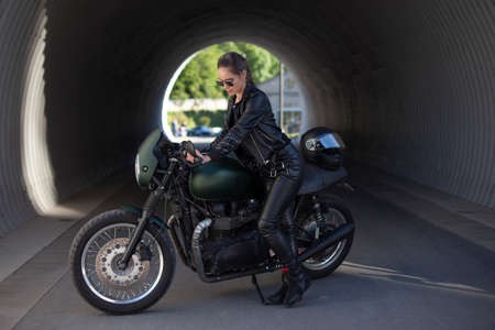 young beautiful girl in black with a motorcycle